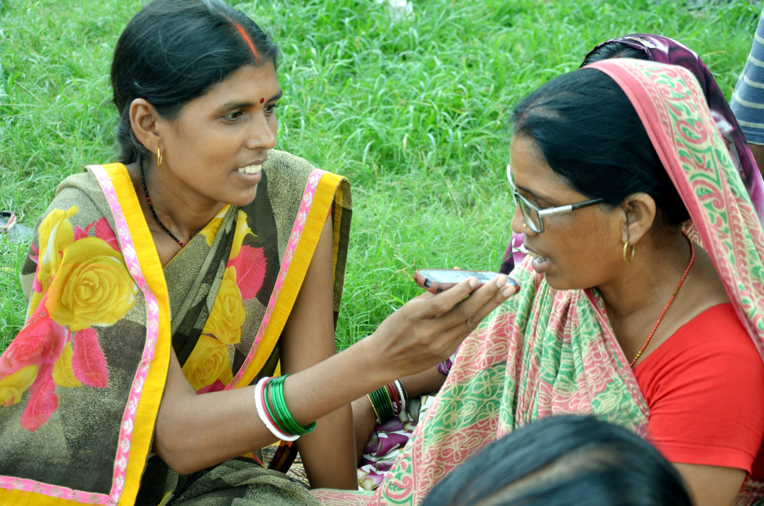 One village woman holds put phone to other